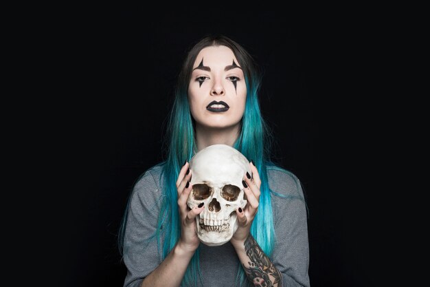 Spooky woman holding human skull