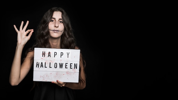 Spooky young female with signboard