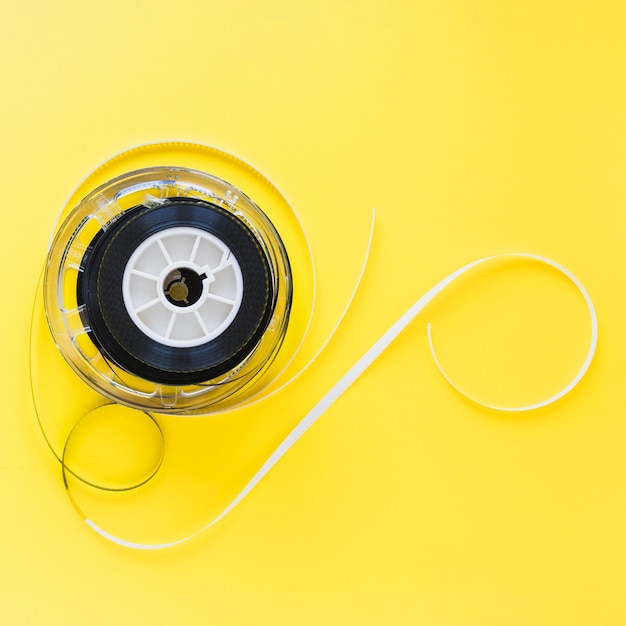 Free Photo spool with film strip on yellow