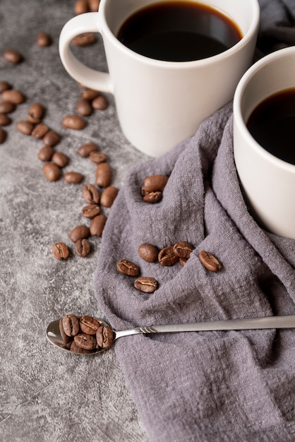 Spoon filled with coffee beans and mugs