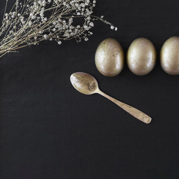 Spoon and flowers near Easter eggs