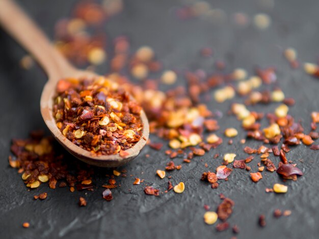 Spoon full of spices on black background