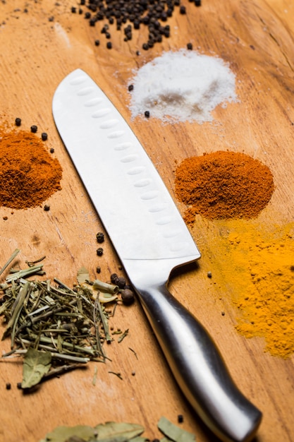 Spoon, knife and heap of spices on the table