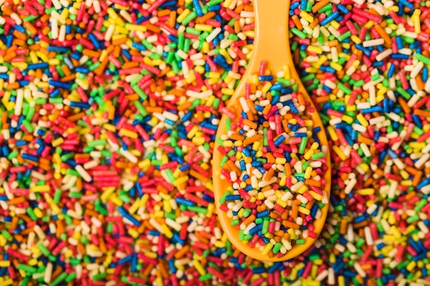 Spoon with sprinkles on heap of sprinkles