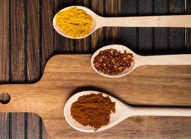 Free photo spoons with hot spices near cutting board