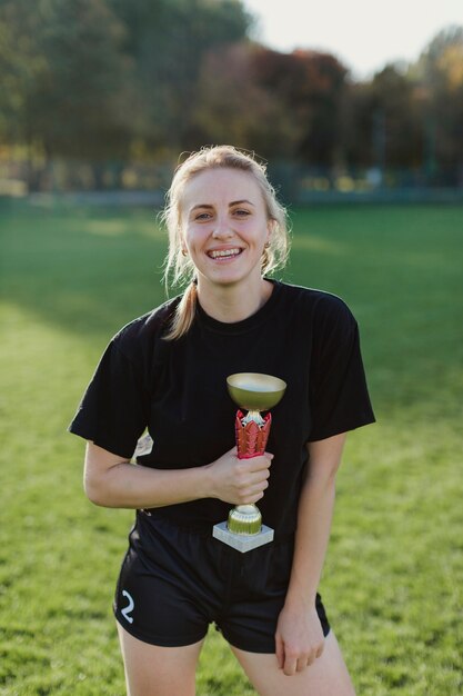 Sportive woman holding a trophy