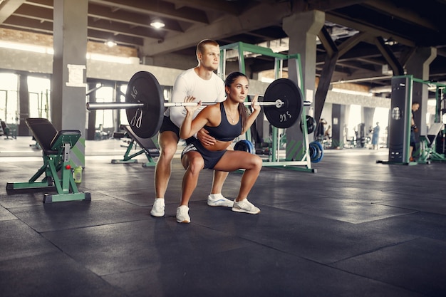 Sports couple in a sportswear training in a gym