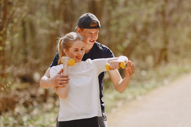 Sports couple training in a summer forest