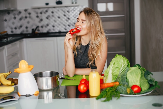 Sports girl in a kitchen with vegetables