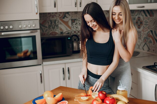 Free photo sports girlss in a kitchen with fruits