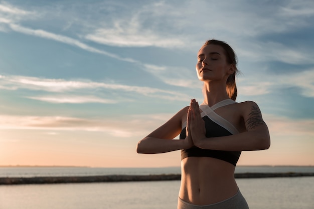 Sports lady at the beach make meditate exercises.