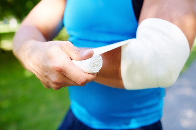 Sportsman bandaging the elbow