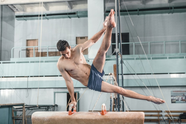 The sportsman during difficult exercise, sports gymnastics