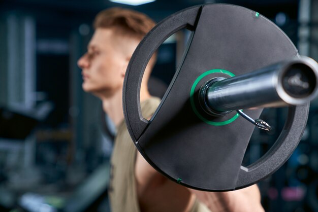 Sportsman holding barbell on shoulders.