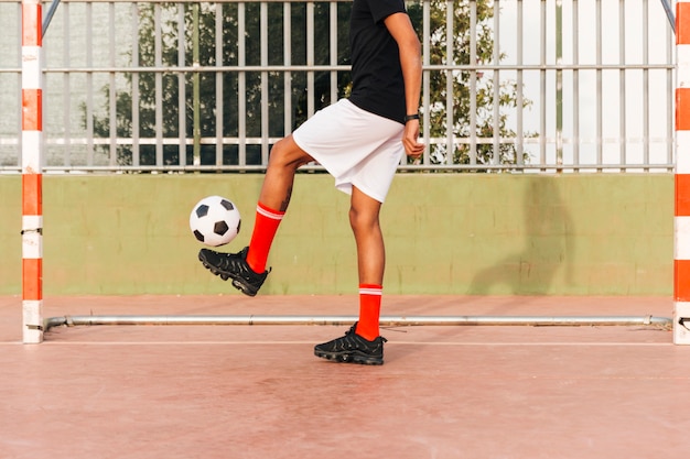 Free photo sportsman kicking football at stadium