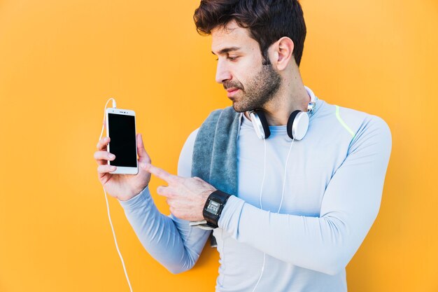 Sportsman pointing at smartphone