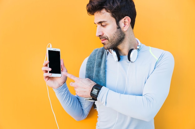 Sportsman pointing at smartphone