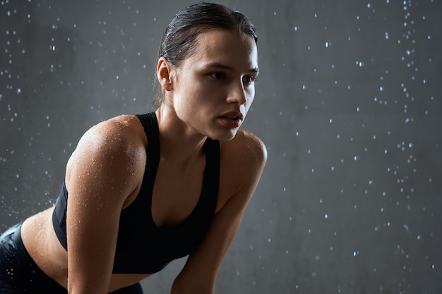 Free photo sportswoman posing in sportswear isolated on gray