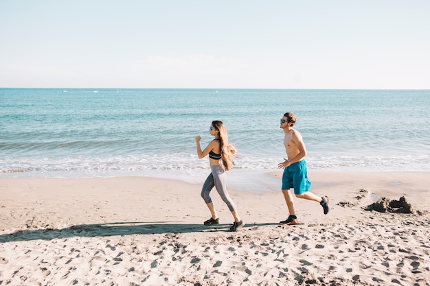 Free photo sporty couple jogging at the beach