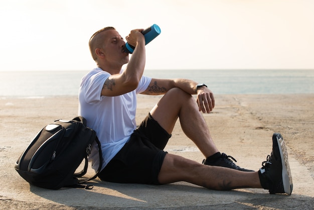 Sporty male athlete being thirsty