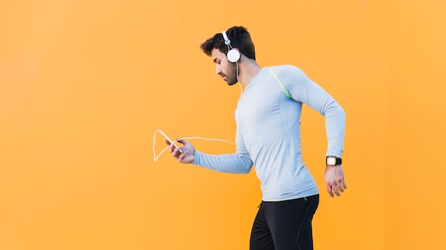 Free Photo sporty man choosing music on smartphone