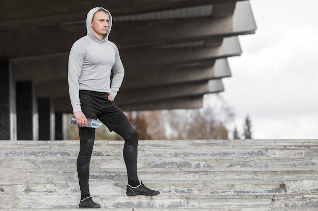 Free photo sporty man sitting on stairs and posing fashion