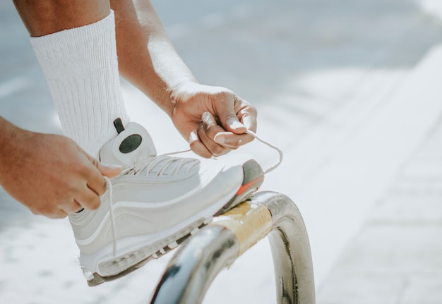 Free photo sporty man tying his shoelaces