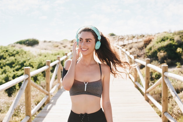 Free Photo sporty woman at beach with headphones