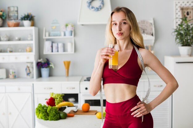 Sporty woman in kitchen with healthy juice