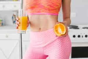 Free photo sporty woman in kitchen with healthy juice