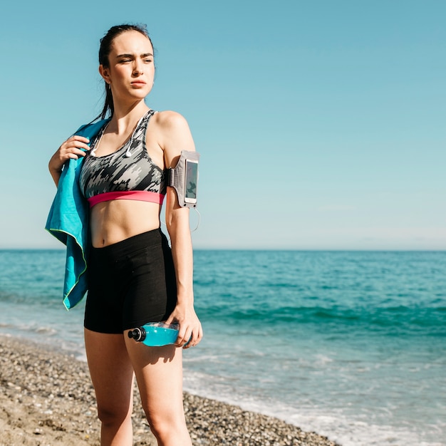 Free photo sporty woman standing at the beach