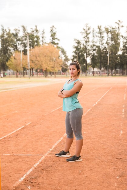 Sporty woman stretching on stadium track