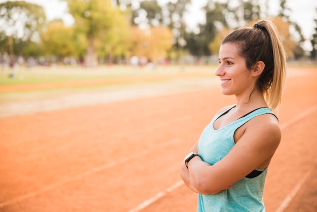 Sporty woman stretching on stadium track