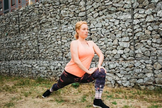 Sporty woman stretching in urban environment