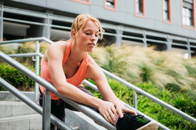 Sporty woman stretching in urban environment