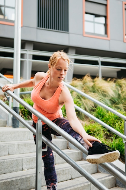 Free Photo sporty woman stretching in urban environment