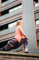 Free photo sporty woman stretching in urban environment