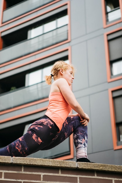 Sporty woman stretching in urban environment