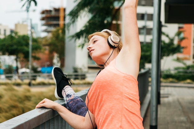 Sporty woman stretching in urban environment