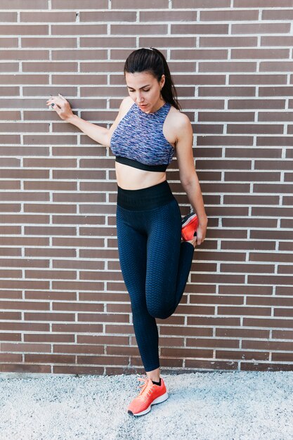 Sporty woman stretching in urban environment