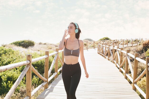 Sporty woman walking with headphones