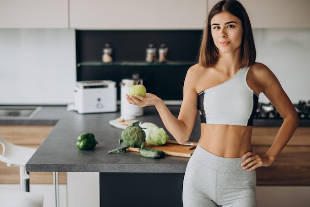 Free photo sporty woman with apple at the kitchen