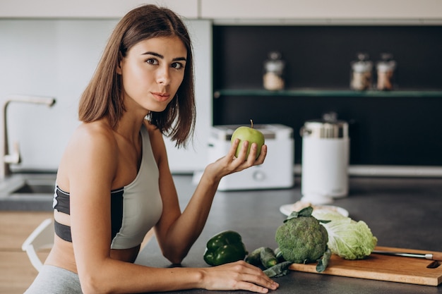 Free Photo sporty woman with apple at the kitchen