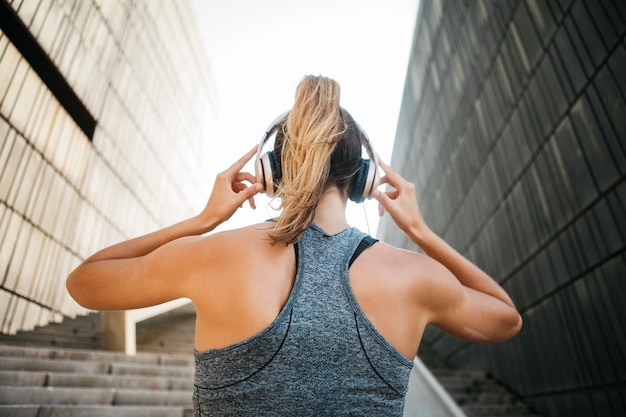 Sporty woman with headphones in urban environment