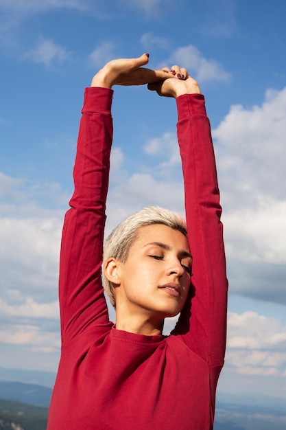 Sporty woman with short hair stretching in nature