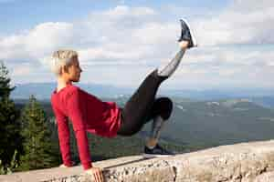 Free photo sporty woman with short hair stretching in nature