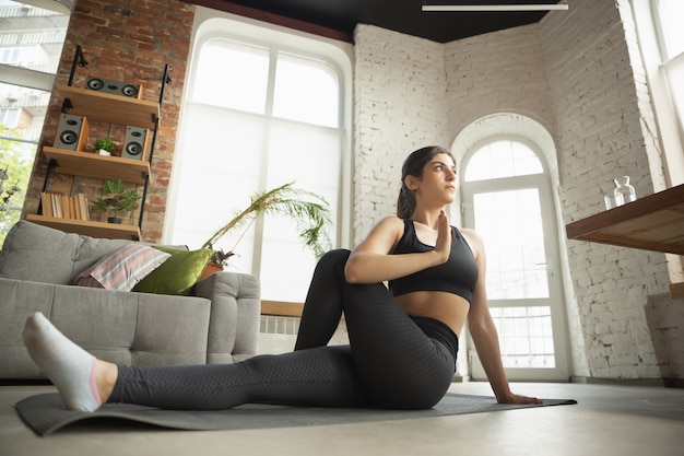 Free photo sporty young muslim woman taking yoga lessons at home