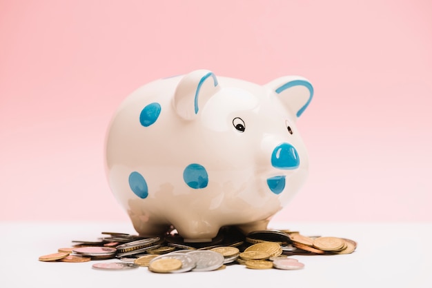 Spotted ceramic piggybank over coins