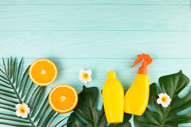 Spray bottles with fruits and plant leaves 