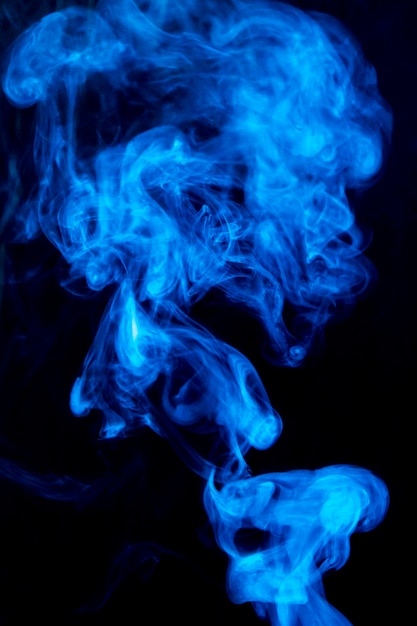 Spread dense blue swirl smoke on black background